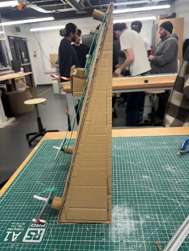 Side view of cardboard model V1 showing a thin, unsteady triangular frame